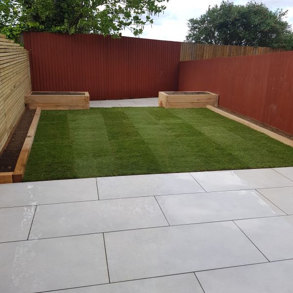 Full re design on this one, Oversized Porcelain paving with Oak sleeper raised beds and a new lawn on this job in West Bridgford : Swipe To View More Images