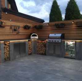 Outdoor living. New outdoor kitchen area we built in gamston. Porcelain tiles clad the granite topped breakfast bar with built in BBQ, fridge and pizza oven. Cedar screens, Porcelain patio and garden lighting : Click Here To View Larger Image